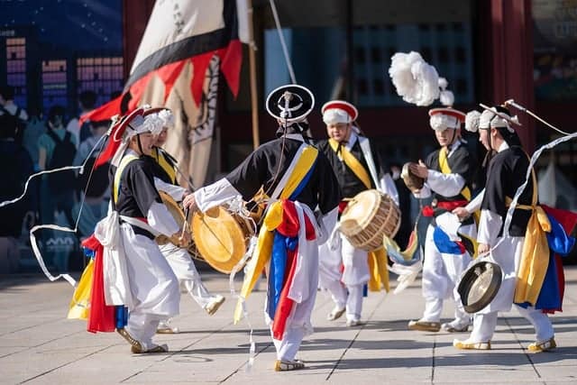 a group of people in clothing playing drums